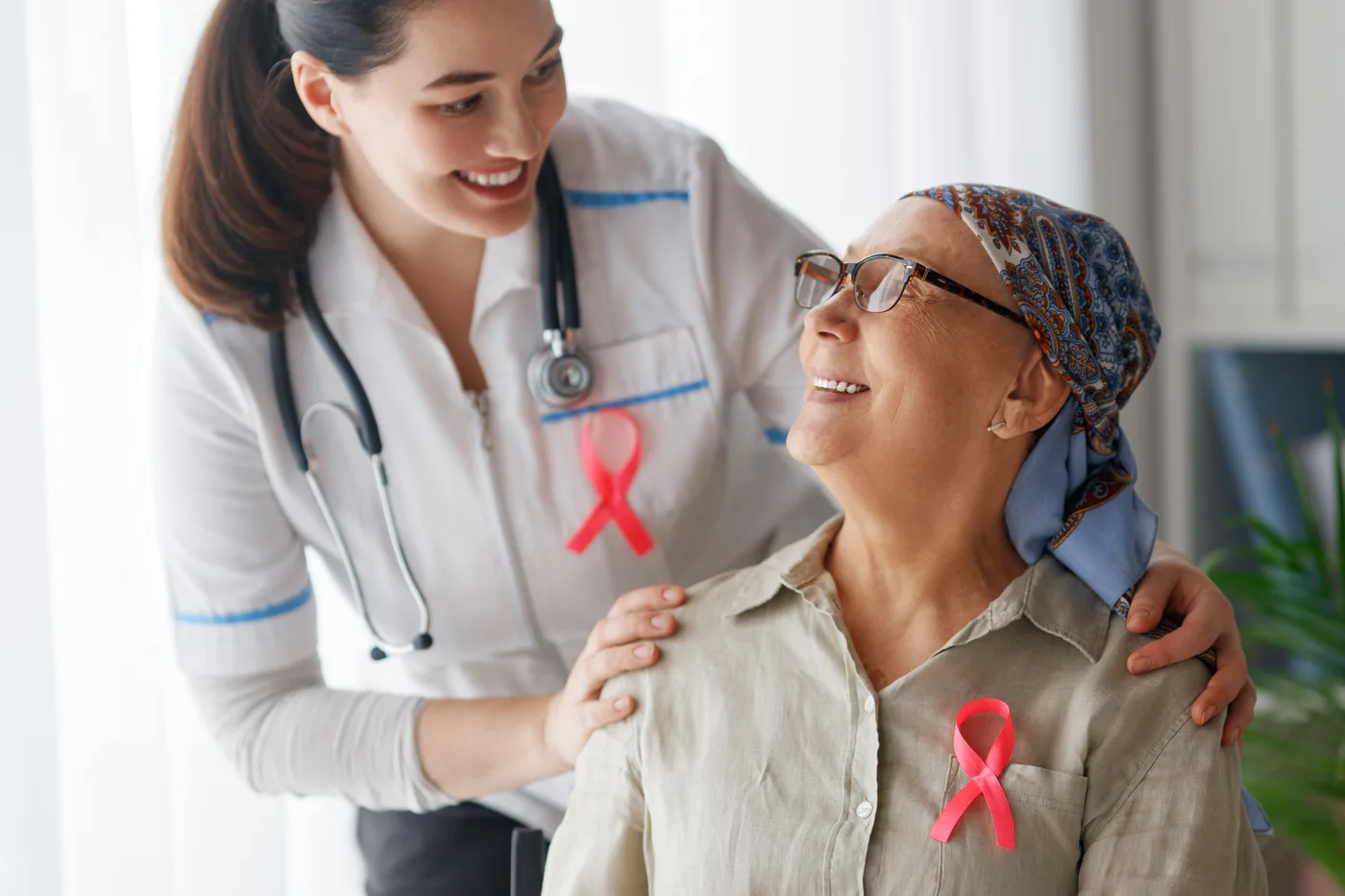 Enfermera acompañando con una sonrisa a una paciente oncológica